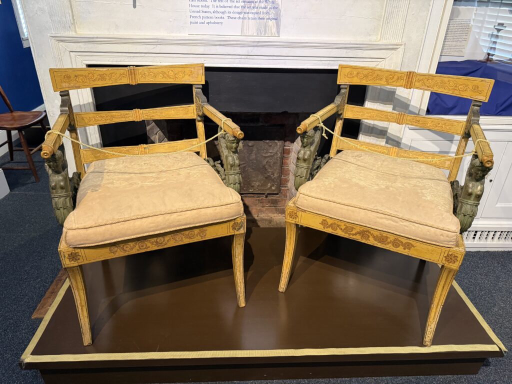 Two Neoclassical chairs placed in front of a fireplace