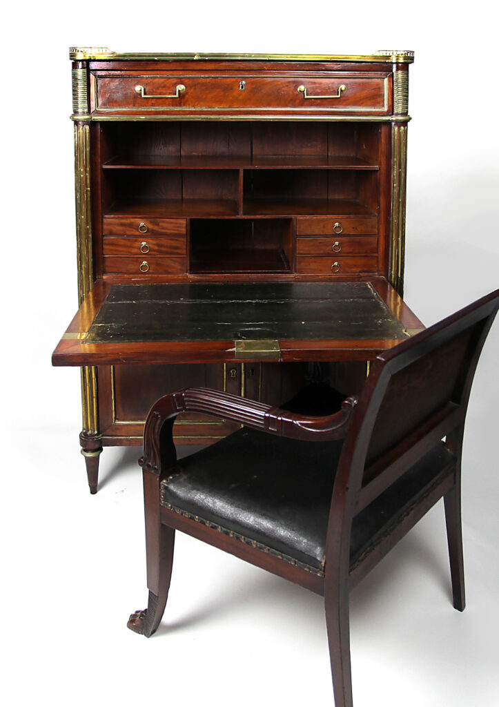 An ornate wooden desk accompanied with a cushioned desk chair